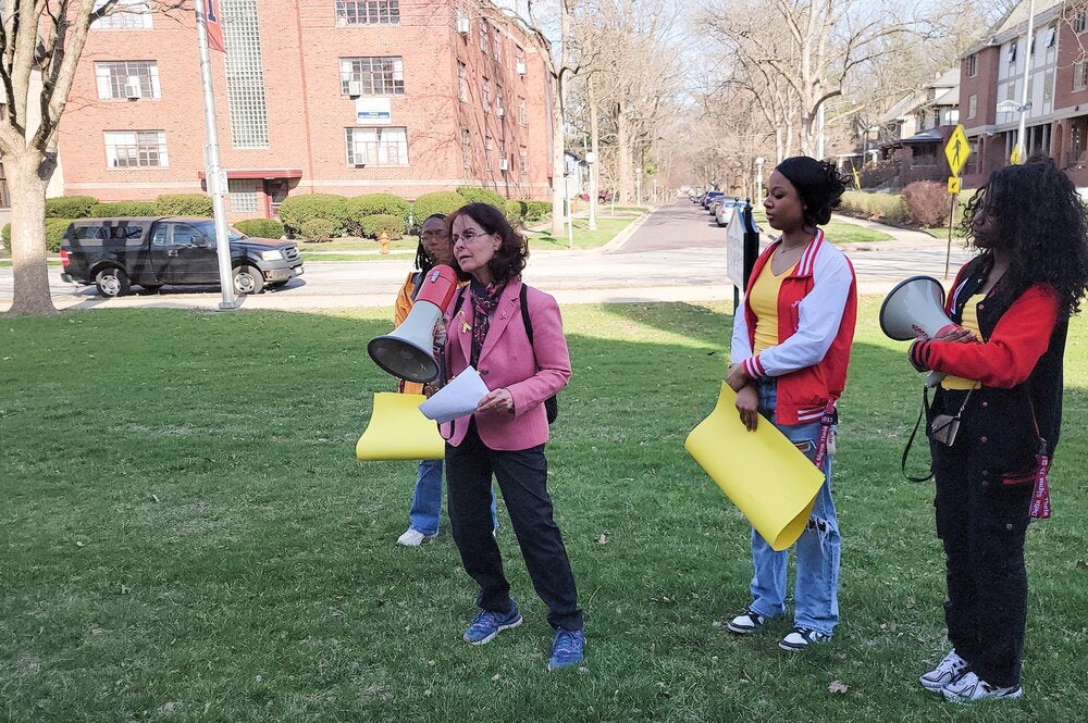 Professor holds megaphone outside health center